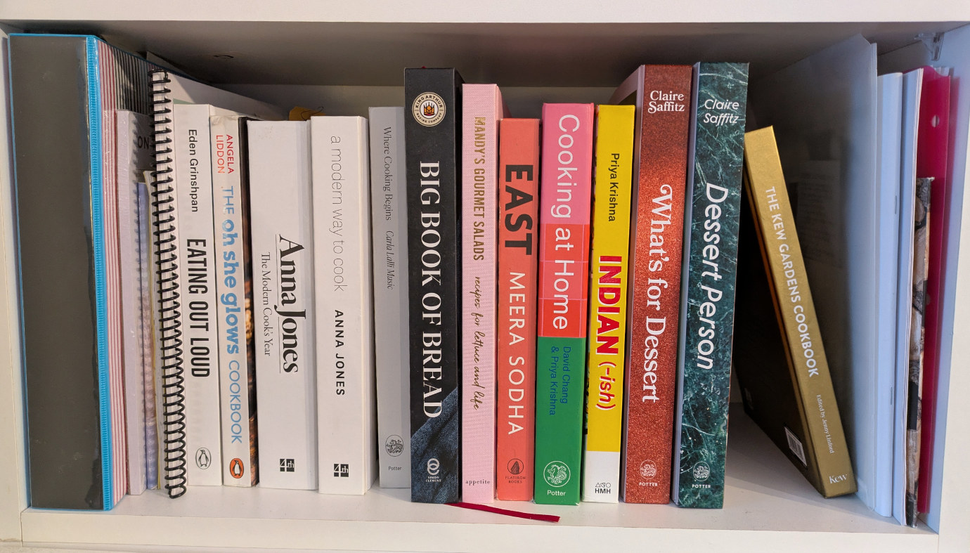 A bookshelf in our house with a line of cookbooks in various colours. Vegetarian cookbooks like Meera Sodha’s “East”, Priya Krishna’s “Indian-ish”, and Anna Jones’ “A modern way to cook” feature prominently.